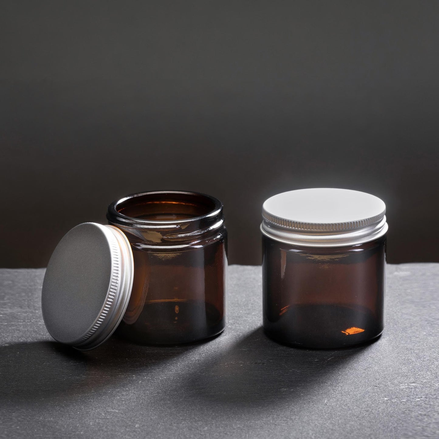 Two amber glass jar candle containers