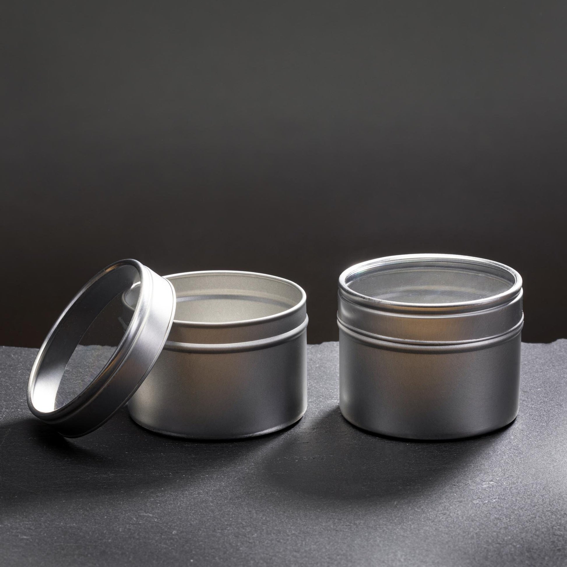 two tin candle containers